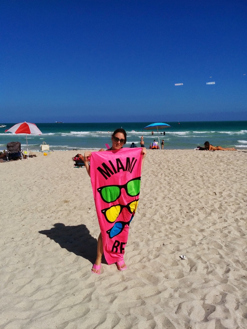 Sarah à Miami, sur la plage avec une serviette rose